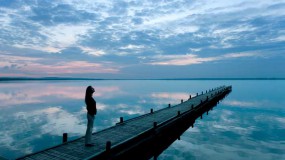 Lady walking on a dock at the ocean