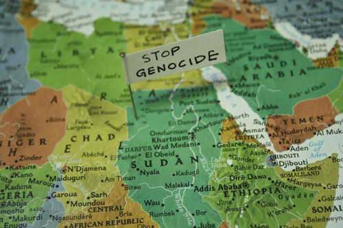 Map close up of Africa with pin and note that says "stop genocide".