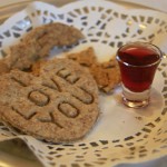 Heart shaped communion bread on lace with grape juice